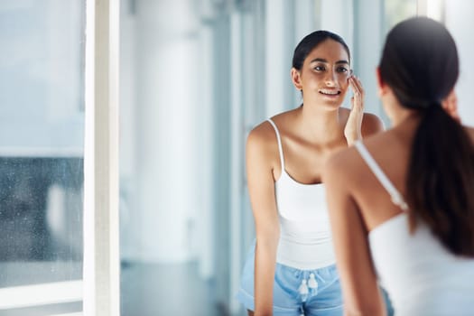 Find your custom-fit skincare routine. an attractive young woman inspecting her skin in front of the bathroom mirror.