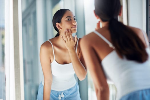 Do you have a problem with acne. an attractive young woman inspecting her skin in front of the bathroom mirror.