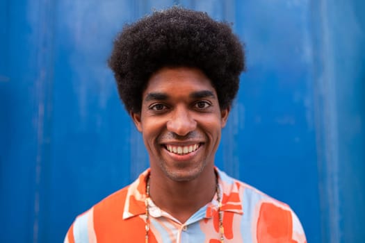 Headshot of smiling young African American man with afro hairstyle looking at camera.