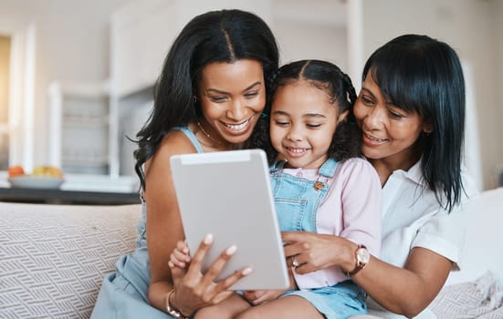Family, tablet and child on a children education app with mother and grandparent at home. Happiness, bonding and kid game on technology with a young girl smile from mom and grandmother help on couch.