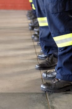 Fireman service, legs and team of firefighter ready for emergency services, disaster prevention or fire fighting. Shoes, safety security and row of people, men or firemen group standing at attention