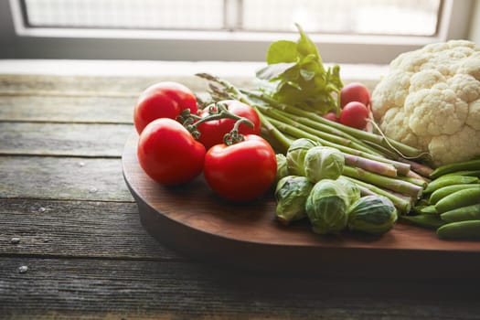 Make organic food a regular feature in your kitchen. a variety of fresh produce on a wooden chopping board.