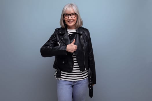 middle age business. 60s mature woman in gray hair in a stylish youth look looks cool on a blue background