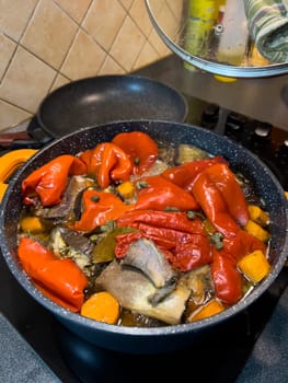 Colorful fragrant lecho is cooked in a frying pan on the stove