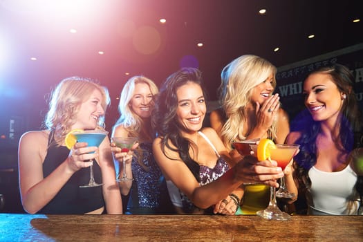 The girls are having fun tonight. young women drinking cocktails in a nightclub.