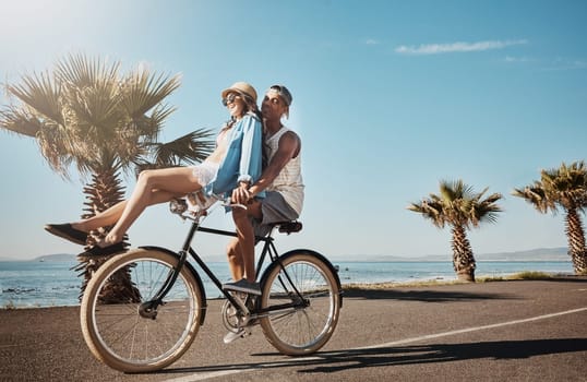 What freedom feels like. a young couple riding a bicycle together on the promenade.
