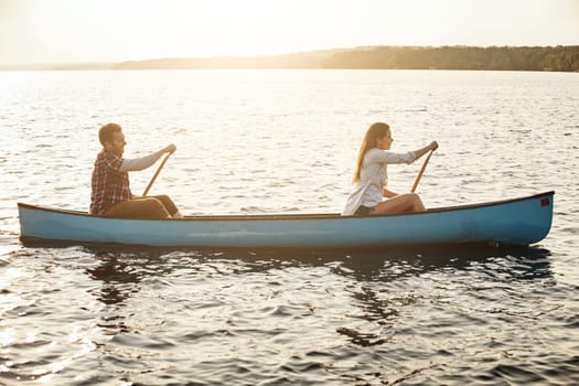 On course for adventure together. a young couple rowing a boat out on the lake.