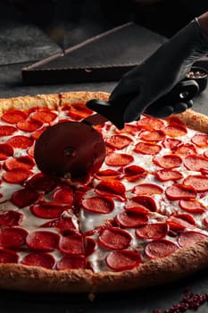 Cutting giant pepperoni pizza with special knife