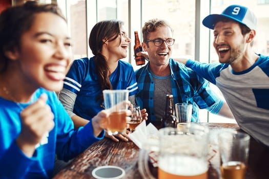 Game time is also bonding time. a group of friends having beers while watching a sports game at a bar