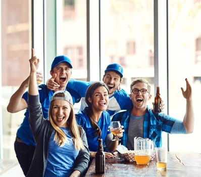 Their blood runs blue as true supporters. a group of friends cheering while watching a sports game at a bar