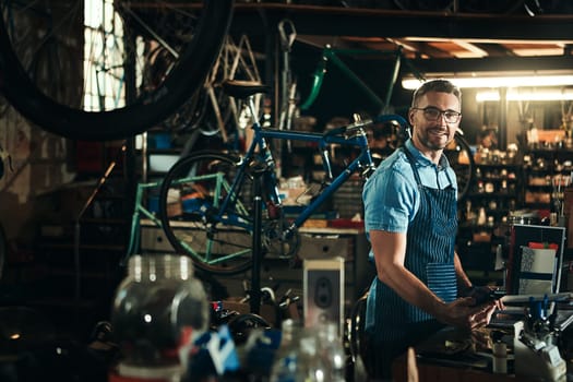 Turned my passion for bicycles into a business. Portrait of a mature man working in a bicycle repair shop.