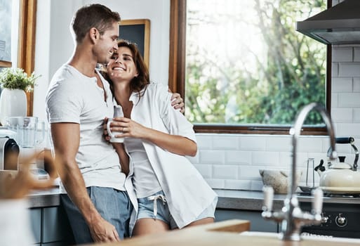 Lazy mornings are the best with you. an affectionate young couple standing together in the kitchen at home.