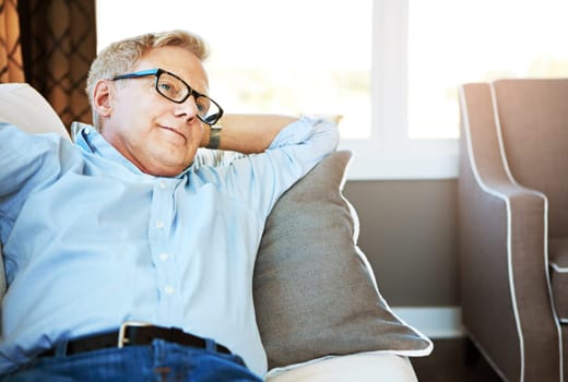 Retirement is the perfect time for rest and relaxation. a happy mature man relaxing on the sofa at home.