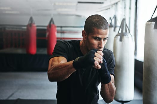 Champions dont quit. a kick-boxer training in a gym.