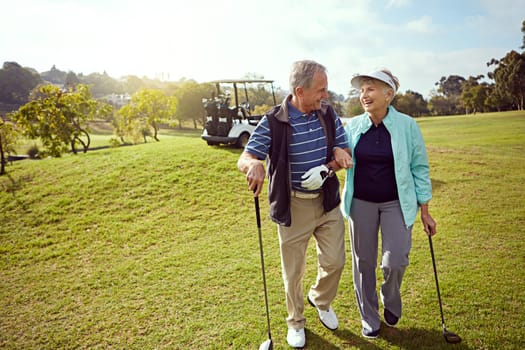 Bonding on the golf course. a smiling senior couple enjoying a day on the golf course.