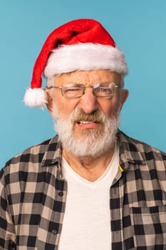 Gloomy angry Santa Claus portrait against blue background. Economy crisis and troubles end of year concept