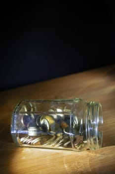 glass jar full of coins for savings concept