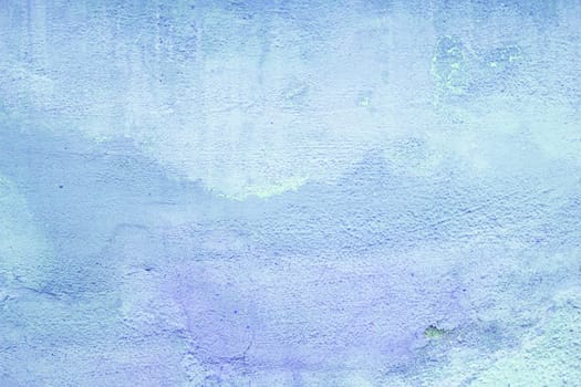 Abstract decorative background of time-damaged blue paint on the wall.