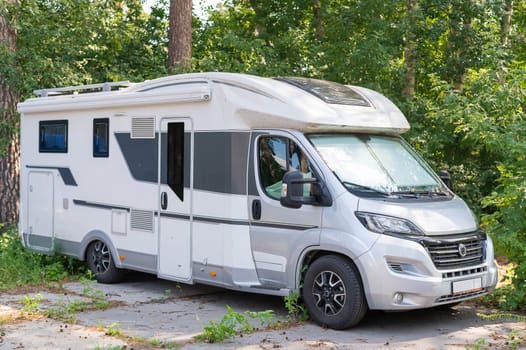 17 july 2020, Russia, Novosibirsk: A white mobile home is parked in the woods. Caravan for life and family road travel. No people