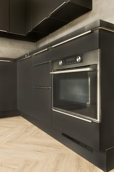 a kitchen with black cabinets and a stainless steel oven