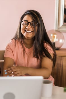 Happy indian woman freelancer or entrepreneur have video conference talking, working remotely online at home office - video call and diversity concept