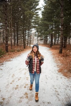 This is a path I have to explore. a young woman hiking in the wilderness during winter.