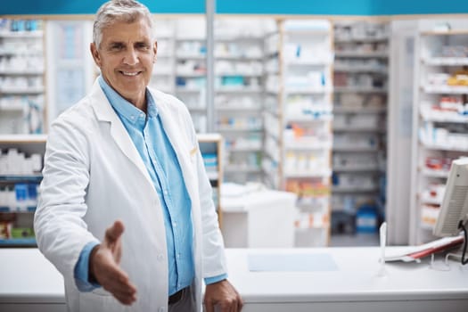 Welcome to the best drugstore in town. a pharmacist extending his arm for a handshake.