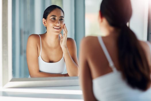 Proper skincare is important. an attractive young woman inspecting her skin in front of the bathroom mirror.
