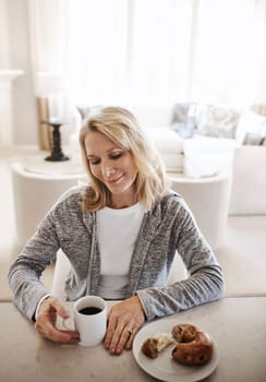Calming moments with a cup of coffee. a mature woman having coffee and a snack during a relaxed day at home.