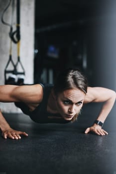Fit is a lifestyle choice. an attractive young woman doing push ups in a gym.