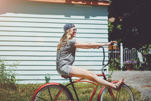 I always follow the fun. an attractive young woman riding a bicycle outdoors.