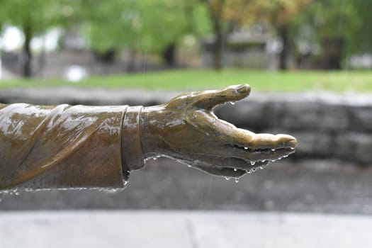 Hand of Statue Dripping Raindrops on a Wet Rainy Day