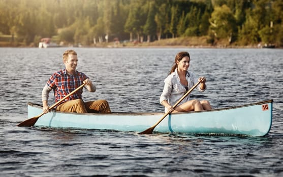 Canoeing is even better when its shared. a young couple going for a canoe ride on the lake.