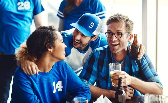 Watching the game with others is an amazing bonding experience. A group of excited friends cheering on their favourite team at the bar.
