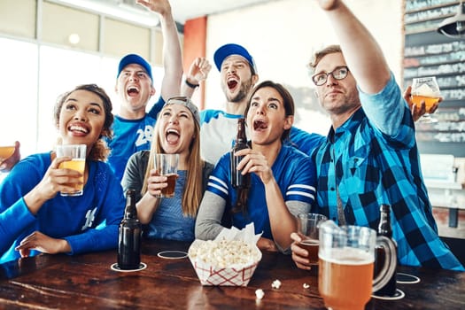 Match day madness. a group of friends cheering while watching a sports game at a bar.
