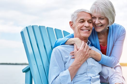 Staying in love is a special thing indeed. an affectionate senior couple relaxing on chairs together outside.