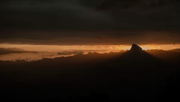 Majestic sunset illuminating mountain range and rock formation