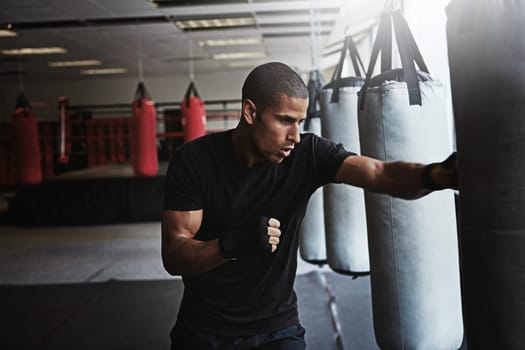 To be the best you have to maintain your focus. a kick-boxer training in a gym.