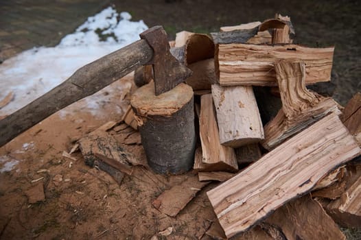 Top view old wooden handle ax in a stump. Firewood for winter. Chopping tree in the forest. Renewable resource of energy