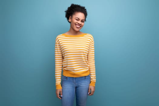 attractive latin young woman with afro hair in a yellow striped blouse