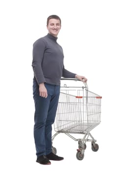 in full growth. casual young man with shopping cart.