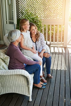 Sharing family stories. Full length shot of a young girl sitting outside with her mother and grandmother.