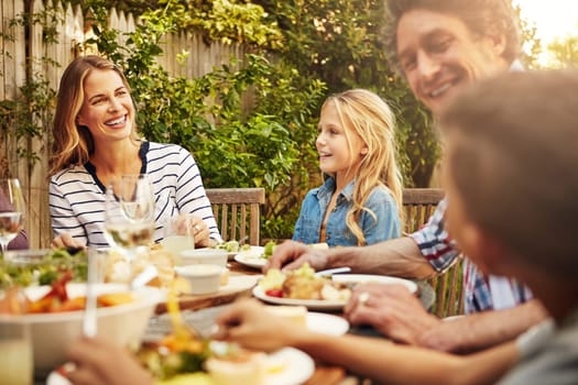 Who better to share your food with than family. a family eating lunch together outdoors.