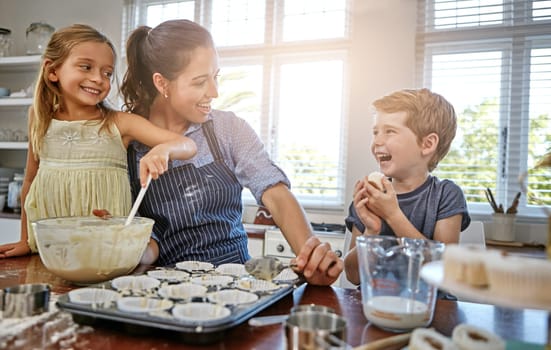 Happiness is only a cupcake away. a mother baking in the kitchen with her daughter and son.