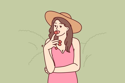 Woman eats appetizing strawberries enjoying taste of fresh berries found on farm or plantation