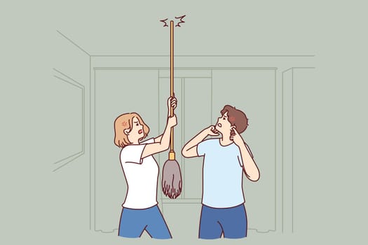 Young couple bangs on ceiling with mop urging neighbors to stop party or turn off loud music
