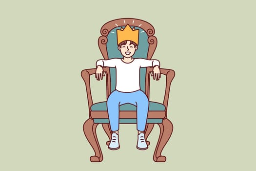Little boy sits on throne with crown on head dreaming of growing up to be prince or king