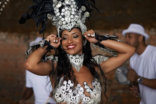 Glamourous dancing queen. a beautiful samba dancer performing in a carnival with her band.