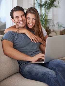 We spend our free time together. Portrait of an affectionate young couple sitting with a laptop at home.