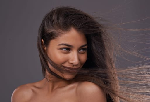 Shes the perfect picture of beauty. A young woman with windswept hair in studio.